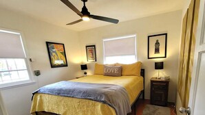 A bedroom with a bed, a ceiling fan, a nightstand, and a door. - Private cottage close to SoFi, FiFa fans welcome! (Long Beach)