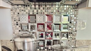 Una cocina con estufa a gas, ollas y sartén.