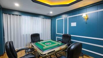 A conference room with a table, four chairs, and a ceiling light fixture.