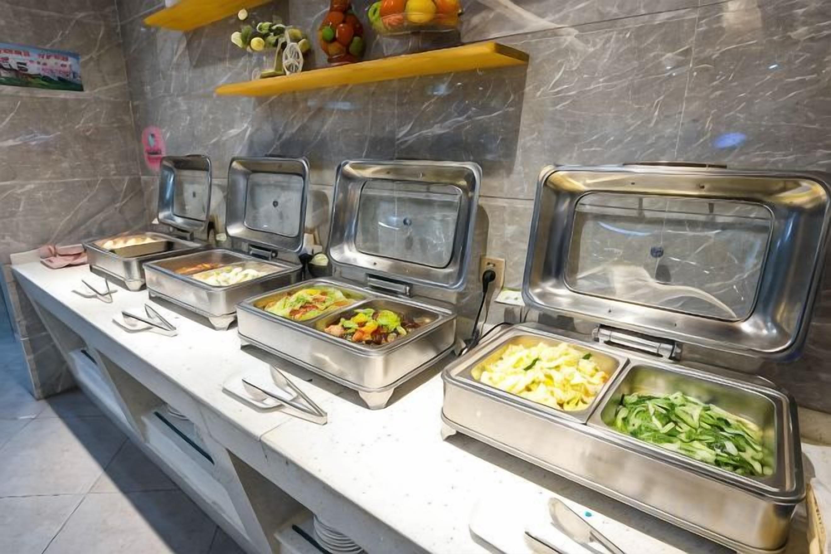 Un bufé con varias estaciones de servicio de alimentos, cada una con un área de exhibición cubierta.