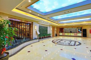 A hotel lobby with a skylight, reception desk, and potted plants. - Landscape Hotel (Longyan Railway Station) (Longyan)