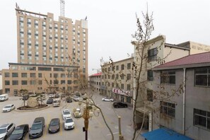 A multi-story building with a parking lot in front. - GreenTree Liaocheng Yanggu Huangshan Road Shizilou (Yanggu)
