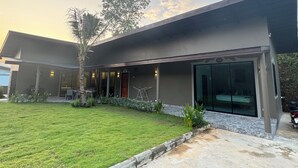 Een modern gebouw met een plat dak, grote ramen en een verzorgd gazon.