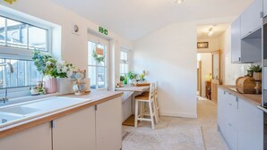 A modern kitchen with white cabinetry, a wooden countertop, and a view to the outside. - 1 bedroom accommodation in Durham (Durham)