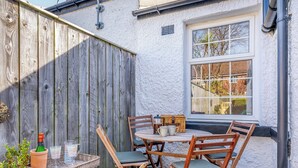 A wooden table with chairs, a window, and a white wall. - 1 bedroom accommodation in Durham (Durham)
