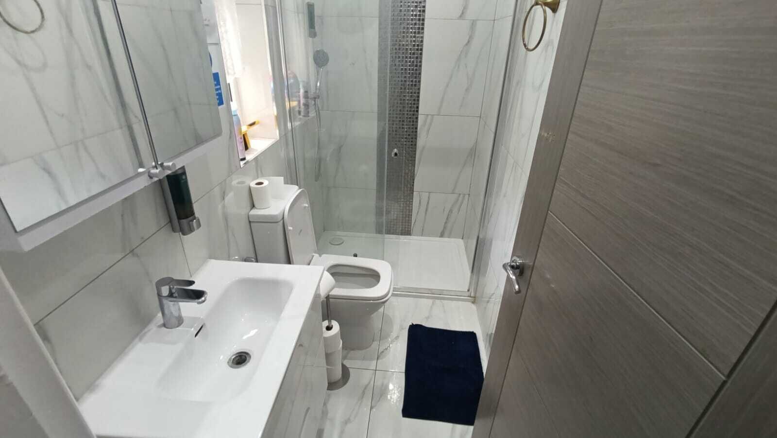 Une salle de bain moderne équipée d’une douche, de toilettes et d’un lavabo.