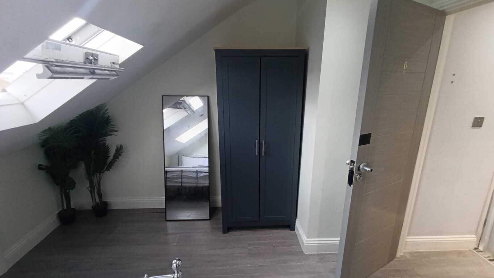 Una habitación con tragaluz, un armario oscuro y una puerta.