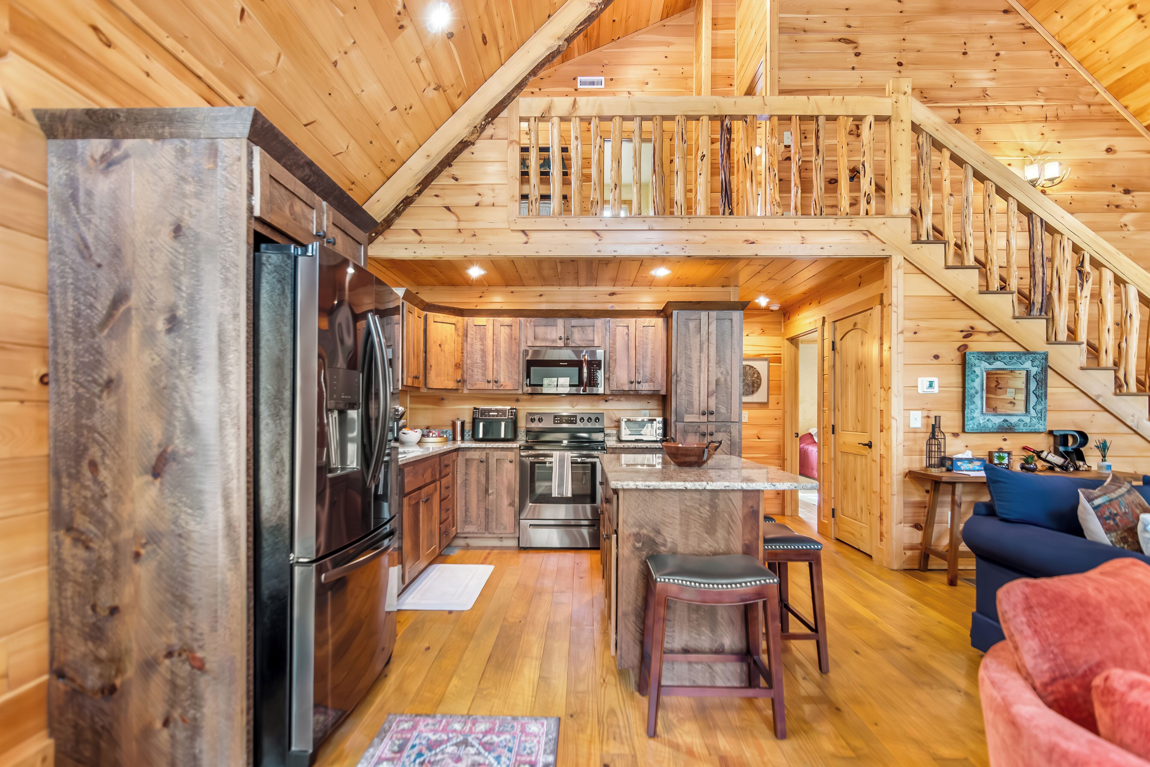 L’intérieur d’une cabane en bois comprend une cuisine, un coin repas et un escalier.