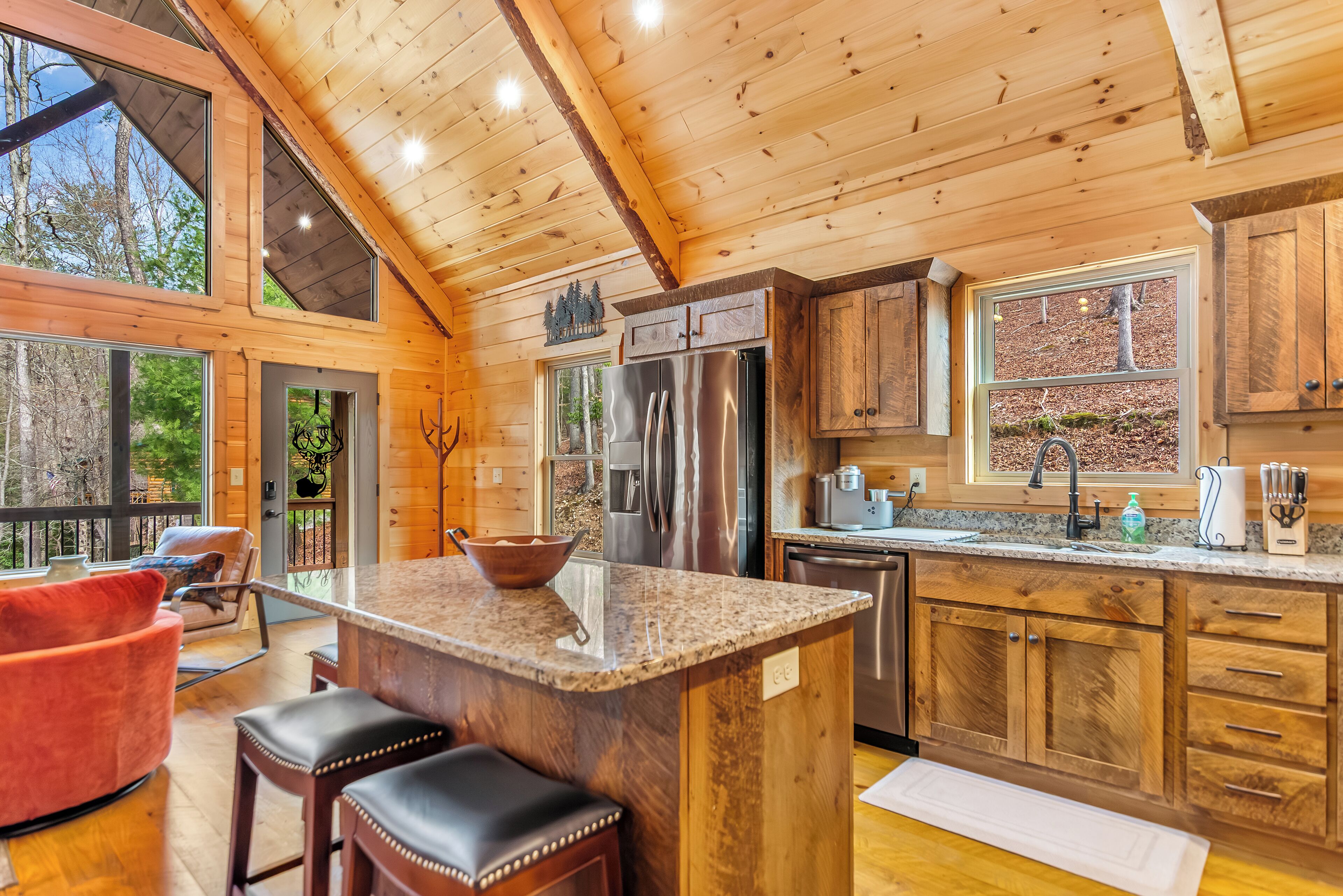 Une cuisine spacieuse dotée de meubles en bois, d’un réfrigérateur en acier inoxydable et d’un grand îlot central avec des places assises.