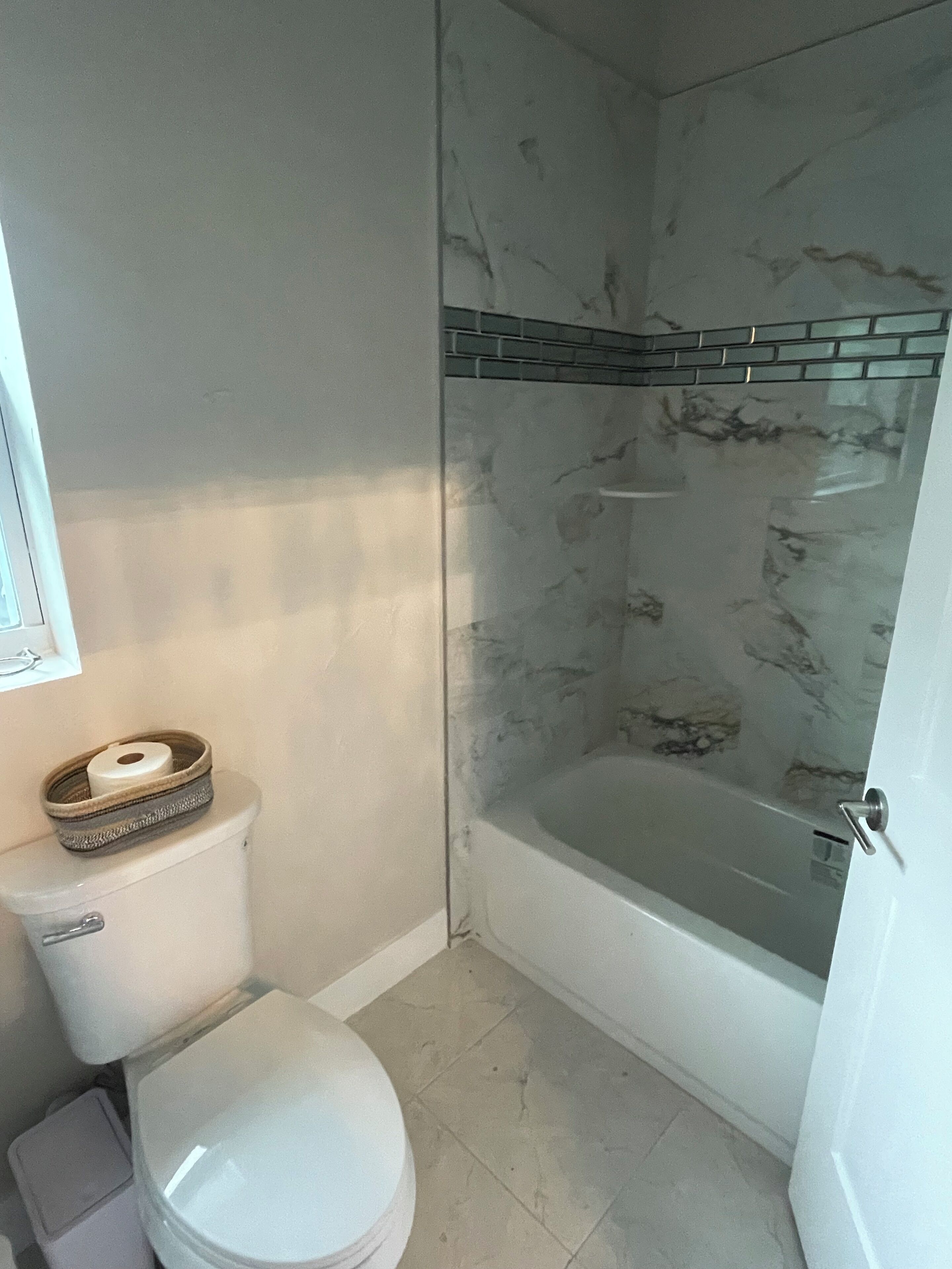 A bathroom with a toilet, a bathtub, and a shower.