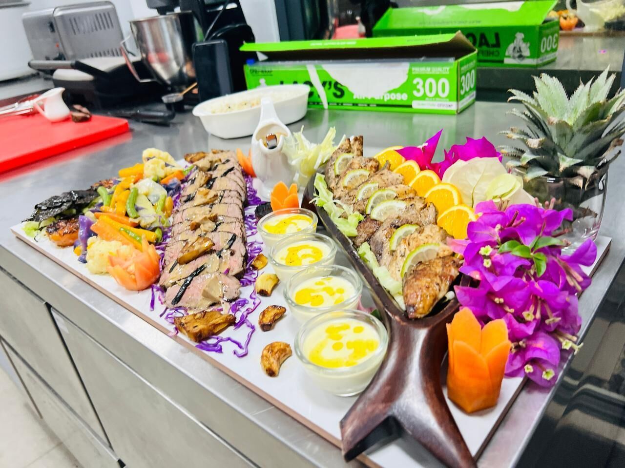 A buffet with various dishes including meats, vegetables, and garnishes.