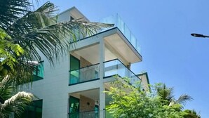 A modern two-story building with a glass balcony, surrounded by lush greenery and a clear sky. - BAGEECHAA STAY (Dharavandhoo)