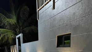 A modern building with a textured facade and recessed lighting. - BAGEECHAA STAY (Dharavandhoo)