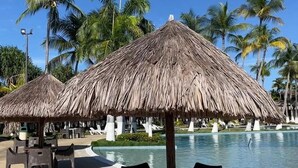 A poolside area with thatched umbrellas and lounge chairs. - Koral OHS Hotel & Marina en Tucacas (Tucacas)