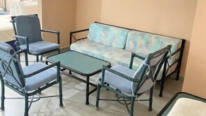 A seating area with a sofa and four chairs, a small table, and a window with curtains. - Koral OHS Hotel & Marina en Tucacas (Tucacas)