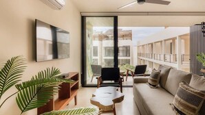 A modern living room with a sofa, chairs, a coffee table, and large windows. - Itzel Samsara Dream Penthouse Beach Club Access (Tulum)
