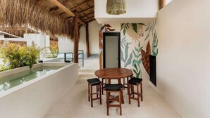 A modern interior with a pool, wooden furniture, and a tropical-themed wall. - Itzel Samsara Dream Penthouse Beach Club Access (Tulum)