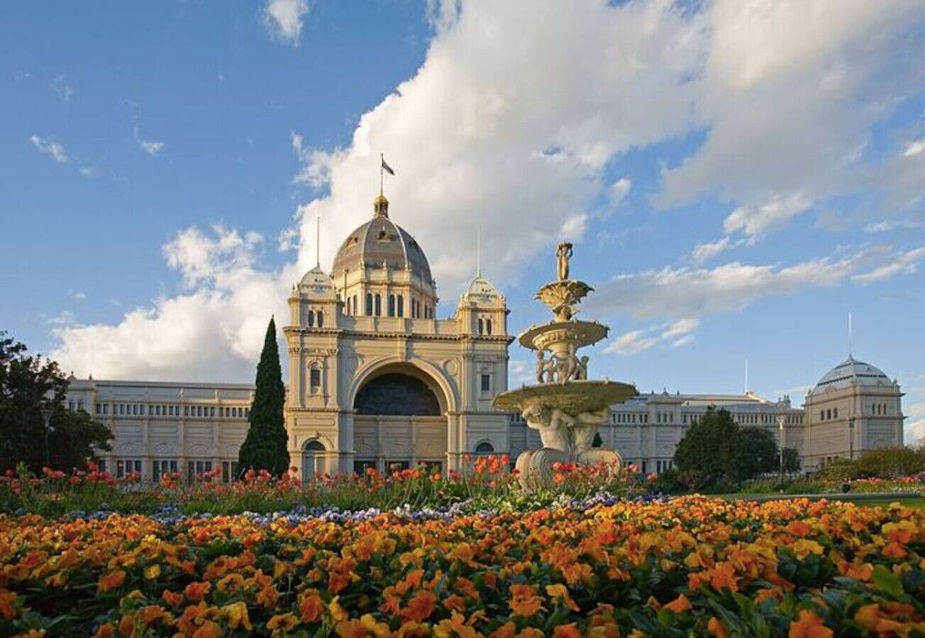A large building with a prominent dome and a fountain in front.