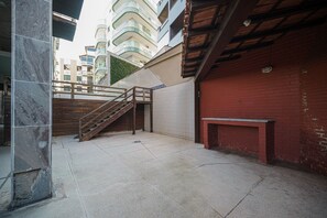 Ein Innenhof mit Treppe, Bank und einer roten Backsteinmauer.