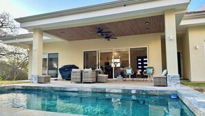 A covered outdoor area with a pool, patio furniture, and a ceiling fan. - 3-bedroom house Casa Tortuga (Coco)