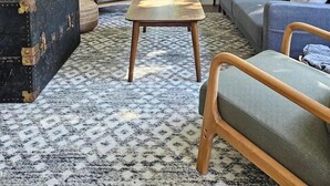 Een knusse woonkamer met een bank, een houten tafel en een vintage koffer.