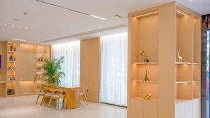 A modern interior with a wooden dining table, chairs, and built-in shelving with decorative items. - Starway Hotel (Bozhou Wanda Plaza) (Bozhou)