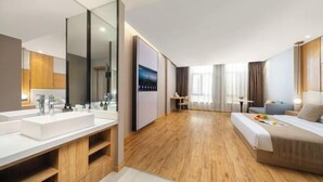 A modern hotel room with a large bed, two sinks, a mirror, and a wooden floor. - Starway Hotel (Bozhou Wanda Plaza) (Bozhou)