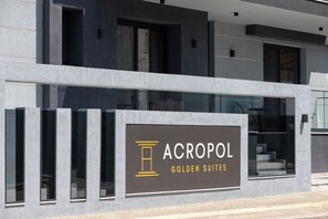 Un immeuble sur lequel on peut lire l’inscription « ACROPOL GOLDEN SUITES ».