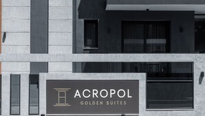 A building with a sign for "ACROPOL GOLDEN SUITES". - Acropol Golden Suites (Neos Marmaras)