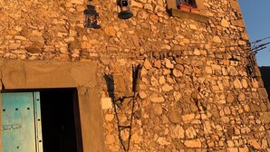 A stone building with two windows and a door.