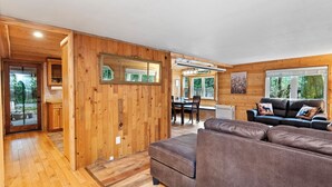 Un interior de madera con un sofá, una mesa de comedor y un espejo.