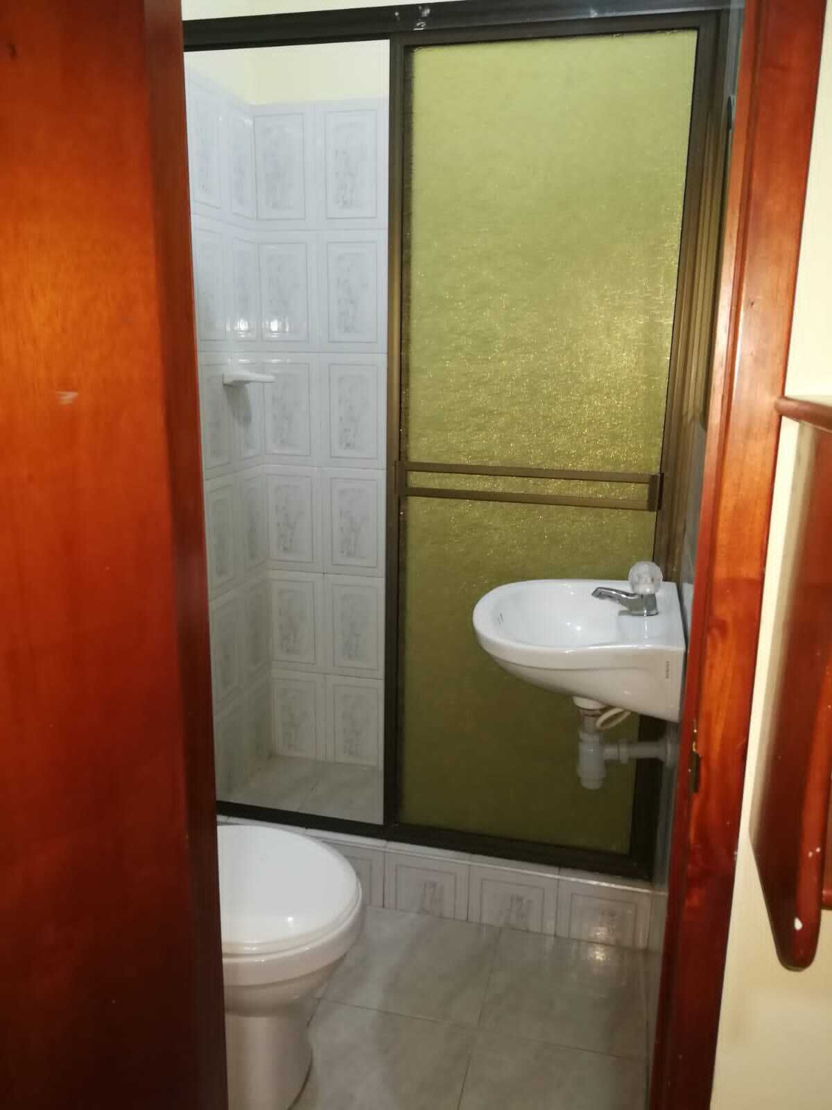 Casa de banho com sanita, lavatório e cabine de duche.