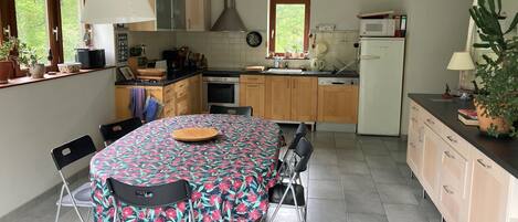 Une cuisine compacte avec un coin repas, comprenant une table avec des chaises, un four à micro-ondes, une cuisinière et des placards.
