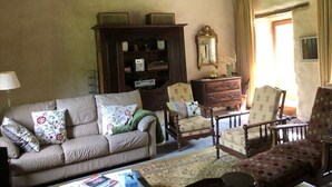 A cozy living room with a sofa, armchairs, a wooden cabinet, and a mirror. - BRETON MANOR (Theix-Noyalo)