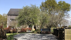 A modern house with a gravel driveway, surrounded by trees and a stone wall. - BRETON MANOR (Theix-Noyalo)