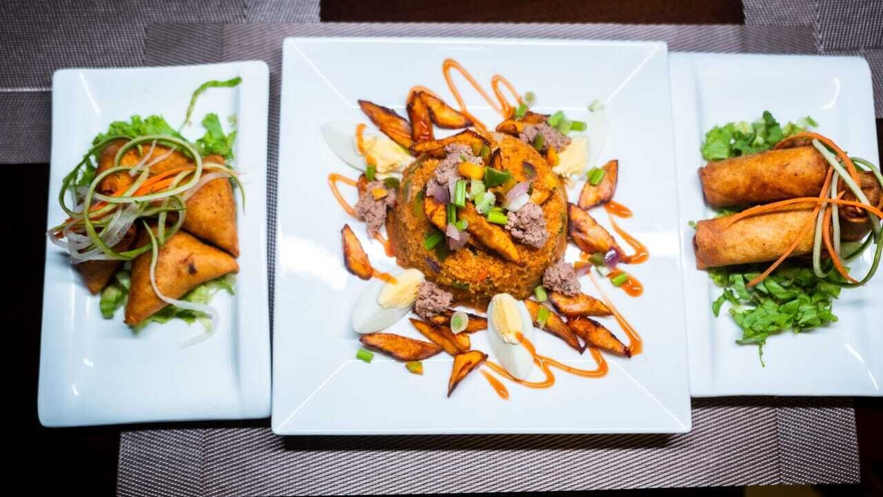 Three square plates of food with various dishes including fried items and vegetables.