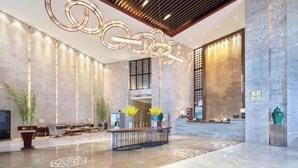 A spacious lobby with a reception desk, seating area, and decorative lighting. - Tianyi International Hotel (Nandujiang Meilan Airport Branch) (Haikou)