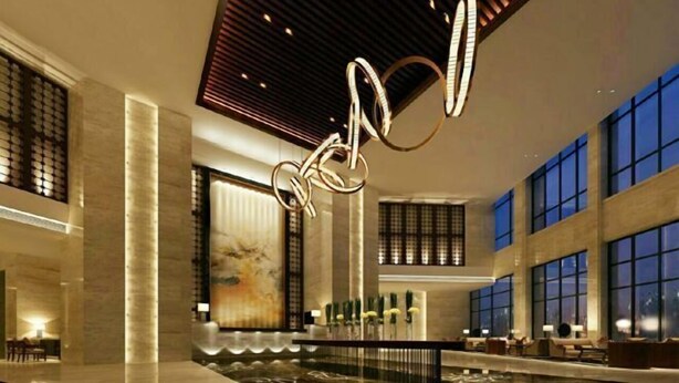A spacious lobby with a large indoor pool, modern lighting fixtures, and large windows. - Tianyi International Hotel (Nandujiang Meilan Airport Branch) (Haikou)