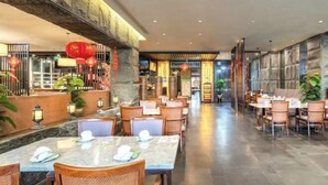 A spacious restaurant with marble tables and chairs, stone walls, and red lanterns. - Tianyi International Hotel (Nandujiang Meilan Airport Branch) (Haikou)
