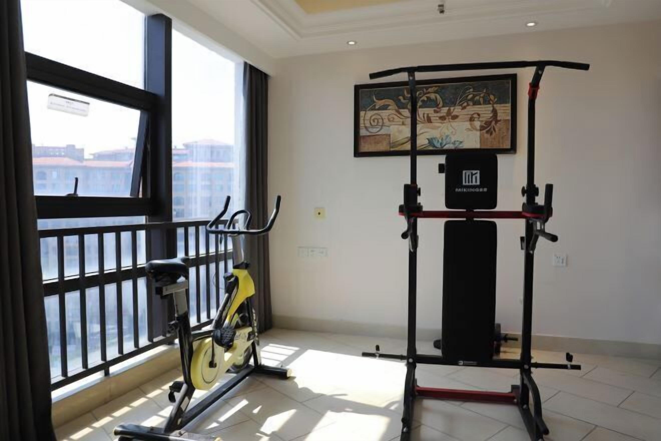 Una palestra con una cyclette, una sbarra per trazioni e una panca per pesi.