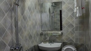 Ein Badezimmer mit Dusche, Waschbecken und Toilette.