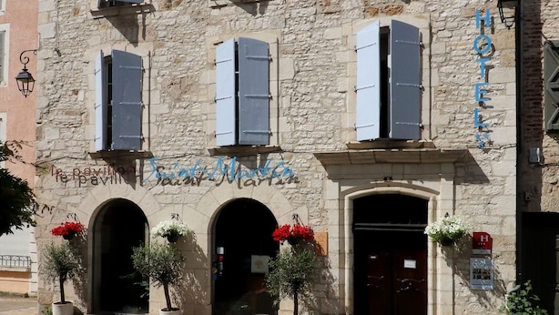 Um edifício histórico de pedra com várias janelas e uma placa com a inscrição 'Hotel de la Mer'.