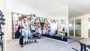 A gym with exercise equipment, a large mirror, and a tiled floor. - Cf02 Cobertura 200m da Praia das Dunas (Cabo Frio)