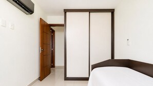 A bedroom with a bed, a wardrobe, and an air conditioning unit. - Cf02 Cobertura 200m da Praia das Dunas (Cabo Frio)