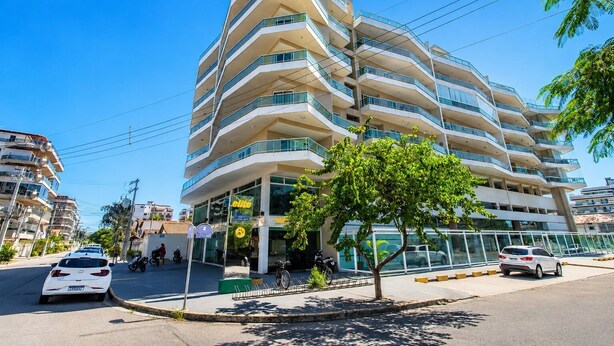 A multi-story hotel with a modern design, featuring balconies and a glass facade. - Cf02 Cobertura 200m da Praia das Dunas (Cabo Frio)