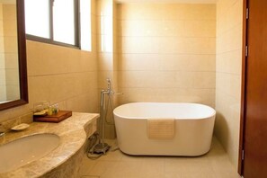 A bathroom with a freestanding bathtub, a sink, and a shower.