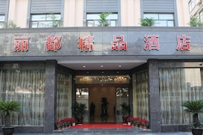 A hotel entrance with a red carpet, large windows, and potted plants. - Lidu Boutique Hotel (Shanghai)