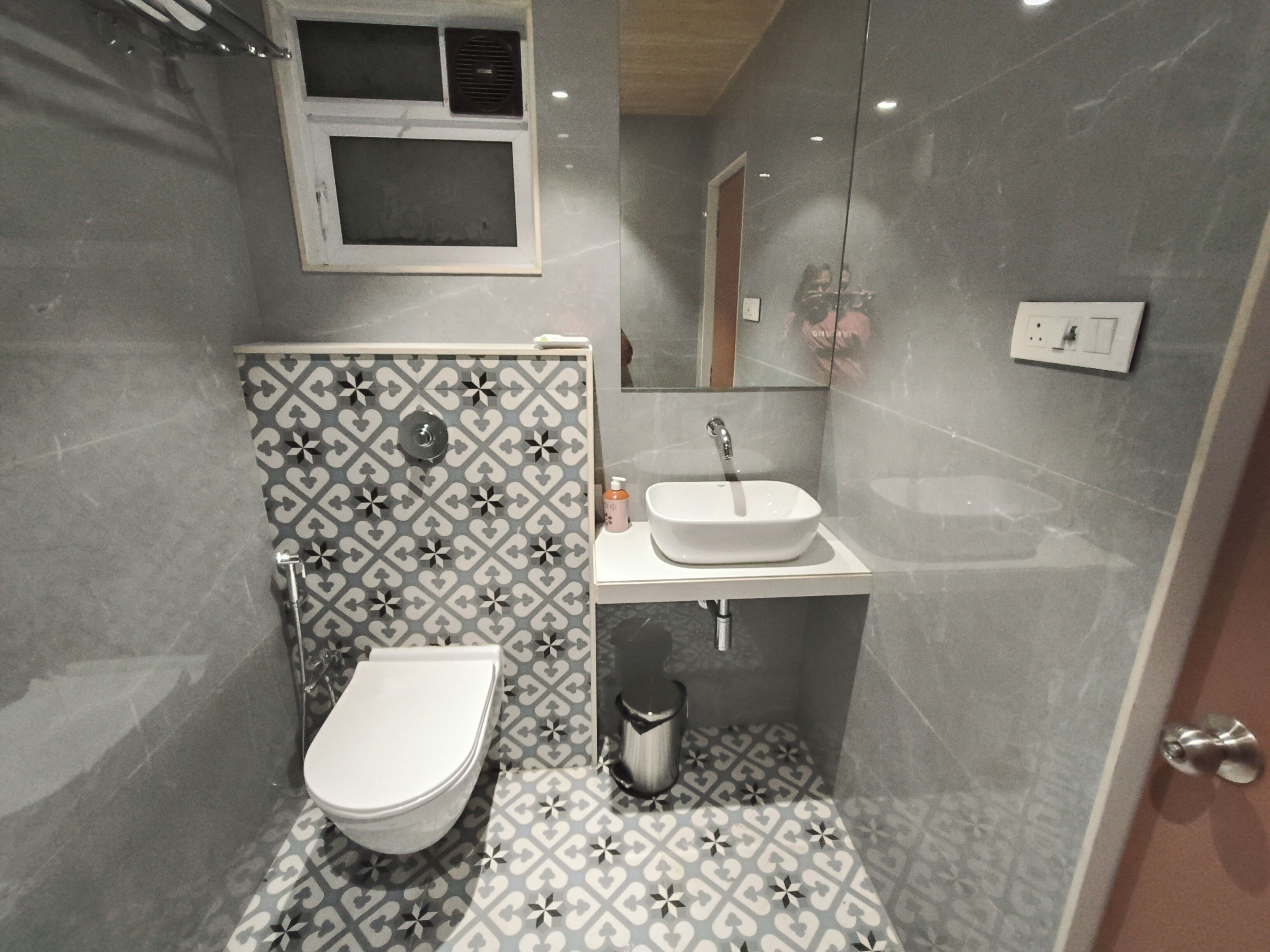 Une salle de bain moderne équipée de toilettes, d’un lavabo et d’un espace douche.