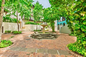 A courtyard with a fountain, brick pathways, and lush greenery. - Beach Villa las Catalina’s (Las Catalinas)