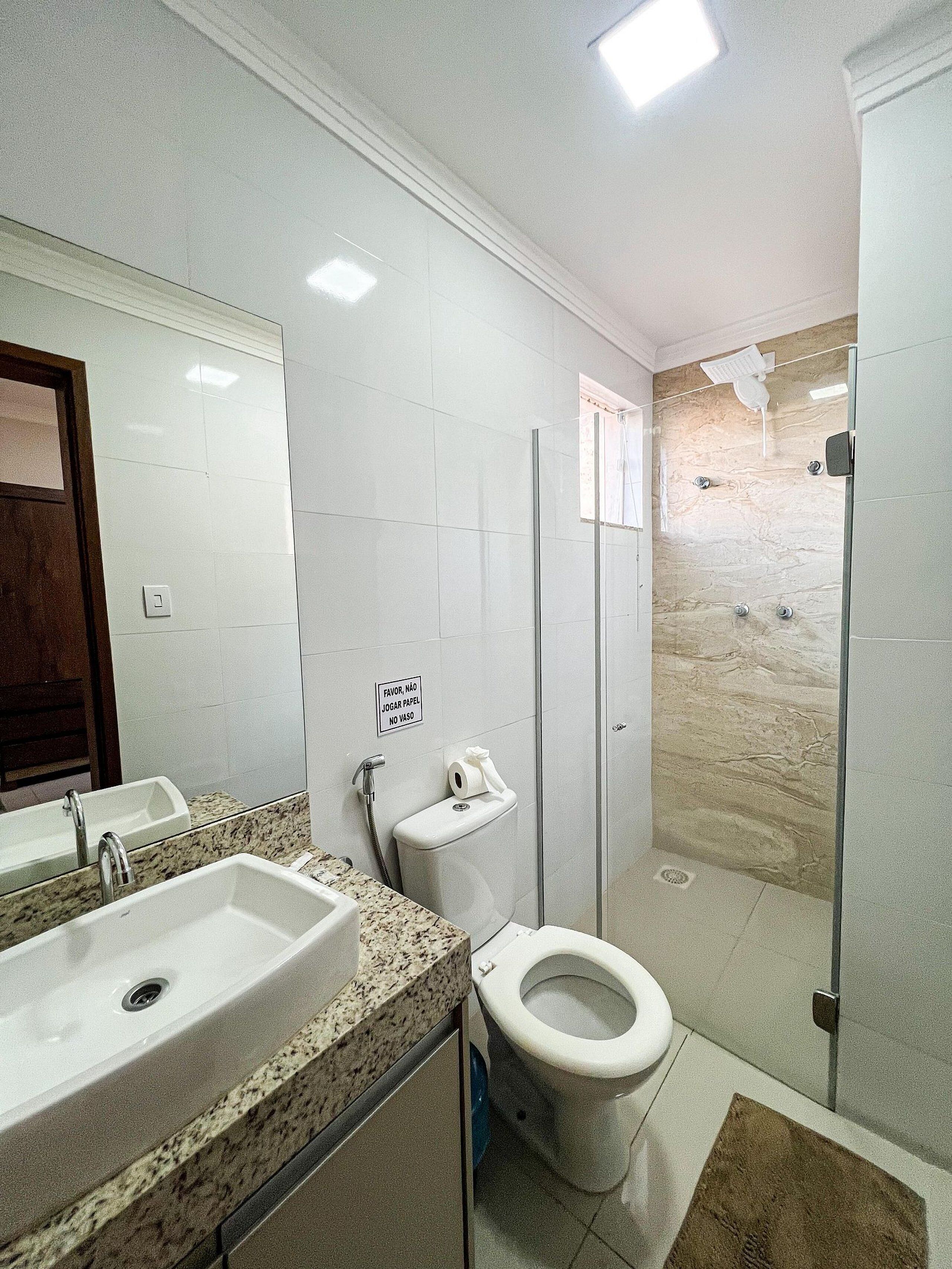A bathroom with a sink, toilet, and shower.